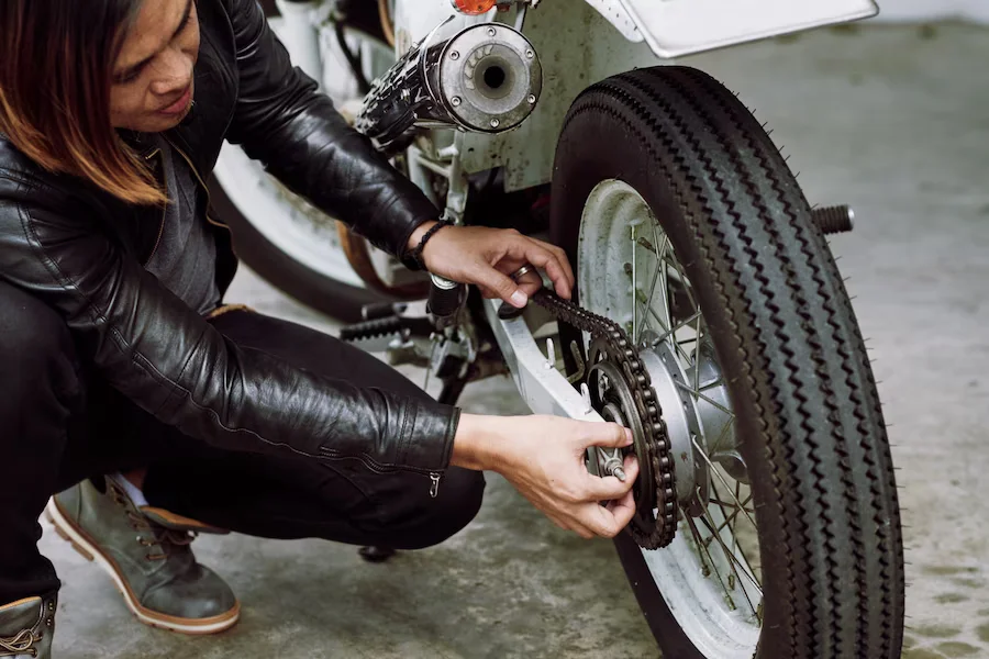 asian biker fixing his motorcycle before ride 1098 19052