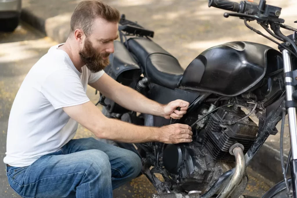 focused rider trying reanimate broken motorbike 1262 17366