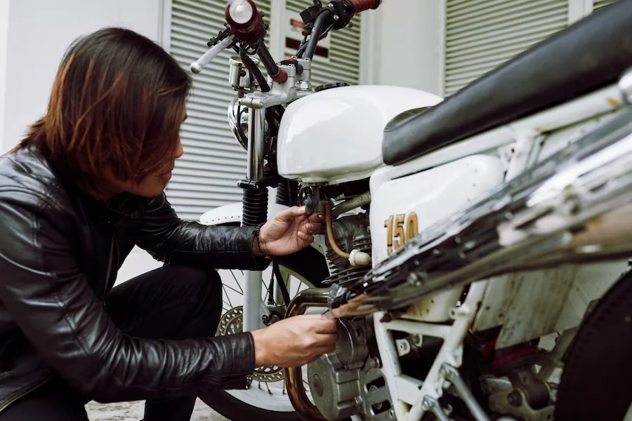 side view motorbiker inspecting his bike before ride 1098 19059 1