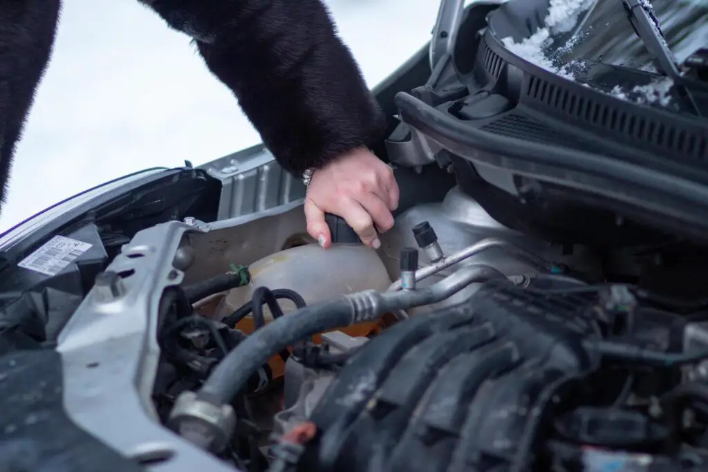 woman checks the presence of antifreeze in the car preparing the car for winter conditions free photo